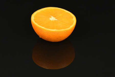 Perfectly retouched orange isolated on acrylic black background. High resolution photo. Full depth of field.の写真素材