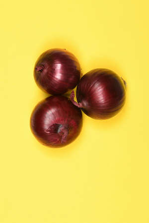 Red onion bulb isolated on yellow background. High resolution photo. Full depth of field.の写真素材