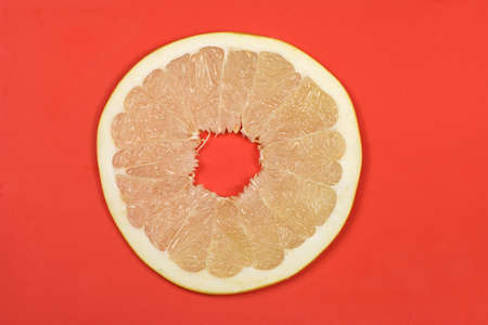 Perfectly retouched pomelo on red background. High resolution photo. Full depth of field.の写真素材