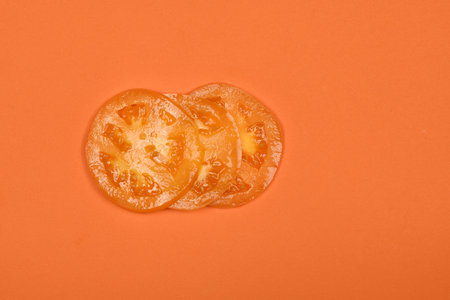 Yellow tomato isolated on orange. High resolution photo. Full depth of field.の写真素材