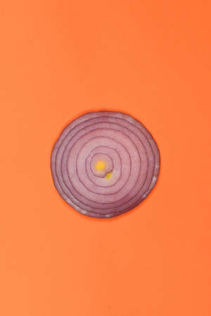 Sliced red onion rings isolated on orange background. High resolution photo. Full depth of field.の写真素材