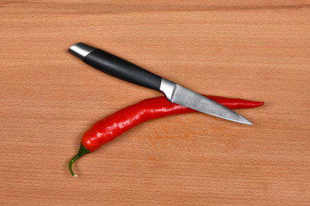 Ripe juicy chili pepper. Chop hot pepper on dark wood background. High resolution photo. Full depth...