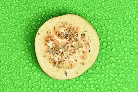 Ripe juicy eggplant with spices. Slice aubergine on green with water drop background. High resolution photo. Full depth of field.の写真素材