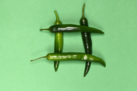 Green chili pepper isolated on green. High resolution photo. Full depth of field.の写真素材