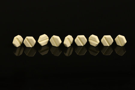 Hexagonal pills on light black acrylic background. extreme closeup. High resolution photo. Full...