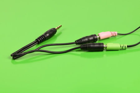 Audio cable splitter, stereo male to two female stereo audio jack 3.5 mm, isolated on a green background. extreme closeup. High resolution photo. Full depth of field.の写真素材