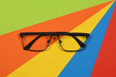 Pair of reading glasses isolated on multi colored background. Fashion spectacles for man and woman. High resolution photo. Full depth of field.の写真素材