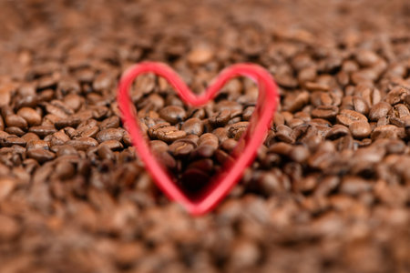 Red heart in roasted coffee beans background. High resolution photo. Soft focus.の写真素材