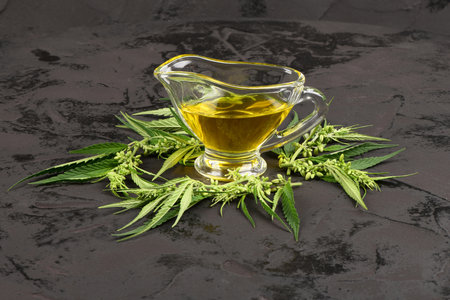 Bowl with hemp oil and leaves, side view. Marijuana plant and cannabis oil.の写真素材