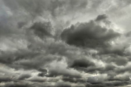 Dark dramatic sky with black stormy clouds before rain or snow as abstract background, extreme...