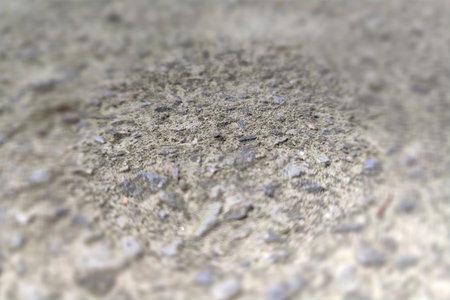 Concrete texture, focus in the center, vignetted frame out of focus.