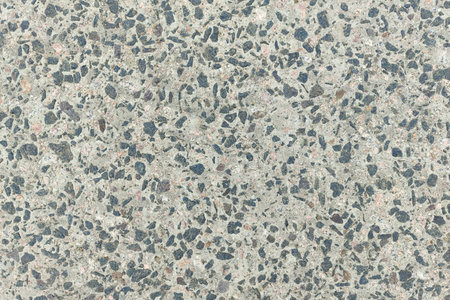 Concrete texture. Pebbles of different colors and signs of aging are visible. Stone wall texture background photo.の写真素材