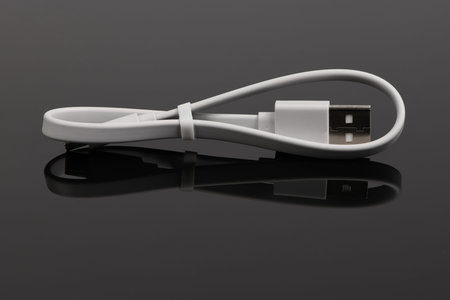 White USB cable on black acrylic background. High resolution photo. Full depth of field.