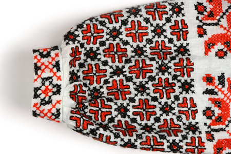 Close-up of the full, gathered sleeve and narrow cuff of a traditional shirt, heavily decorated with...