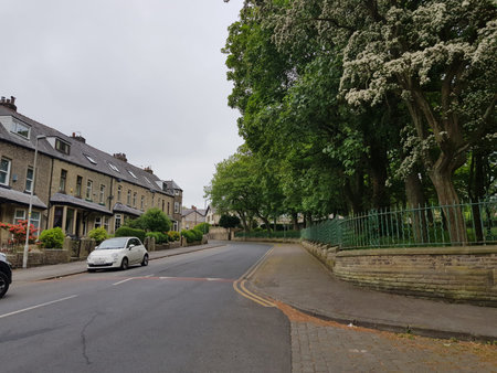Street view at the edge of town at the entrance to a park on a cloud filled summer morning.