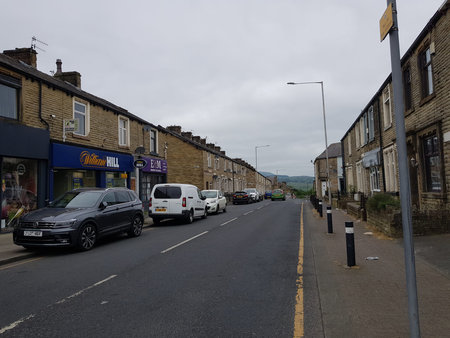 Street view on a cloudy summer day with terraced houses stretching in to the distance.