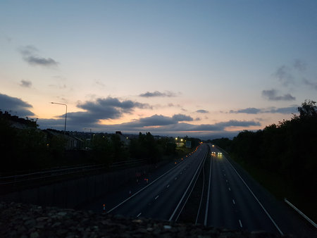 Beautiful summer sunrise over the motorway as it passes a village in the English countryside with...