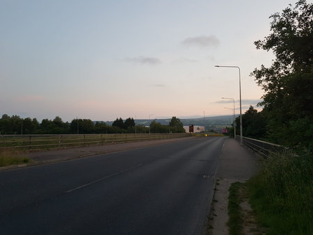 Serene summer landscape of a deserted road disappearing into the English countryside as dawn breaks...
