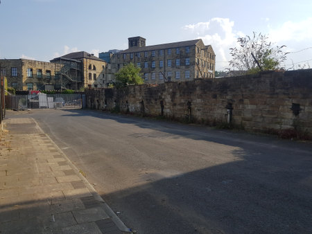 Old industrial age factory building on a beautiful summer day at the edge of town, sunlit historical townscape.の写真素材