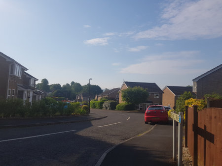 Sunlit view from the entrance to a housing estate on a bright summer morning.の写真素材