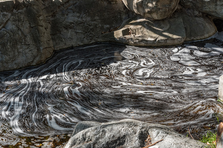 Swirling foam pattern at the surface of a streamの写真素材