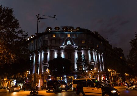 Scenic Barcelona street view with lots of traffic and beautifully illuminated building on a rainy eveningのeditorial素材