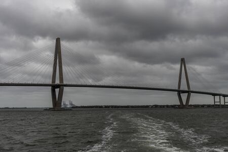 Panoramic vista of the Charleston bay and Arthur Ravenel Jr. Bridge on a heavily overcast day viewed from the water, South Carolinaの写真素材