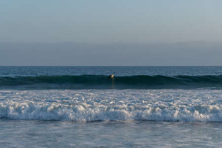 Surfing at Zuma Beach at sunset at high tide, Malibu, Southern Californiaの写真素材