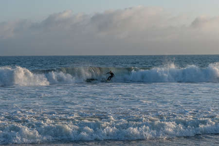Surfing at Zuma Beach at sunset at high tide, Malibu, Southern Californiaのeditorial素材