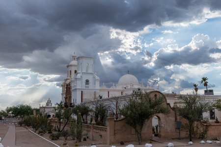 Beautiful vista of the San Xavier del Bac Mission in Tucson, Arizona, under dramatic monsoon skyの写真素材