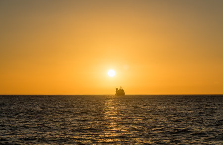 Beautiful west Oahu sunset with a ship silhouette at the horizonの写真素材