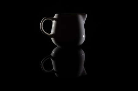 Silhouette of a white milkman on a black background with reflectionの写真素材