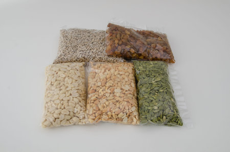 Nuts and seeds in transparent packaging on a white background. Shopping in the store