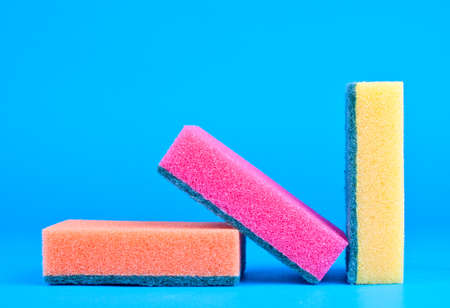 Three kitchen sponges colored on blue backgroundの写真素材