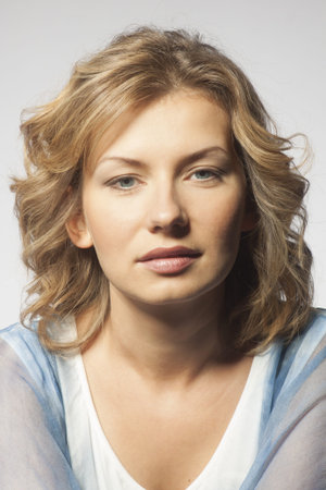 Portrait of a young woman  Her hair is wild and she is wearing a blue dress which is off one...