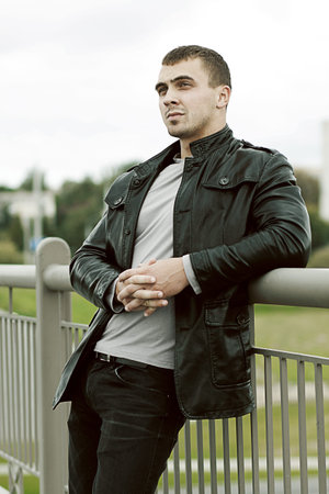 portrait of the brutal young sexual man in a leather jacket