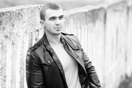 portrait of the brutal young man in a leather jacket. Black-white.の写真素材