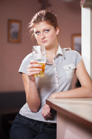 Beautiful girl with a beer at the bar