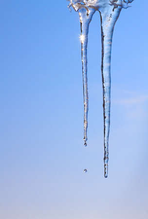 Two melting icicles against a winter skyの写真素材