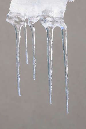 Group of melting icicles against a winter skyの写真素材