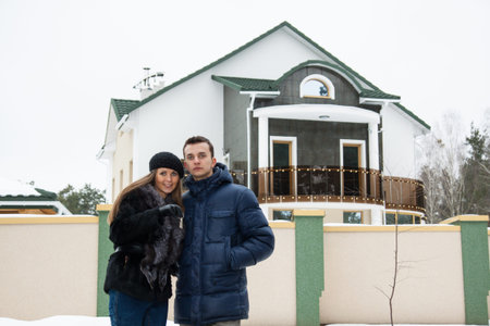 Young beautiful couple standing embracing near his new houseの写真素材