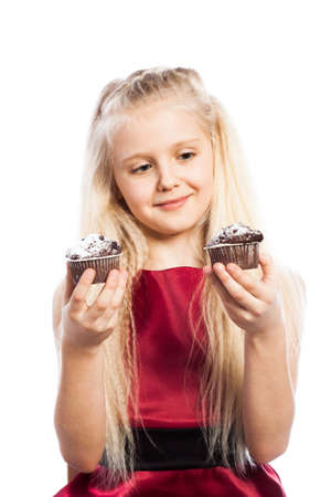 Girl making a choice between two cakes. Isolated on white background.の写真素材