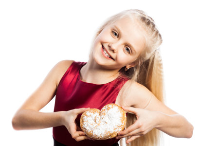Girl holding a heart-shaped biscuit. Isolated on white background.の写真素材