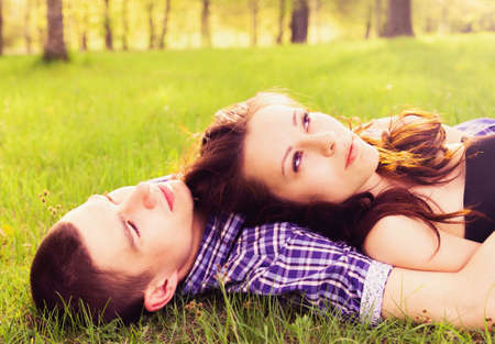 Young happy couple resting on the grass.の写真素材