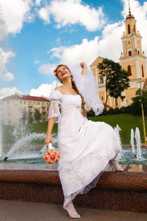Beautiful happy bride posing near by fountainの写真素材