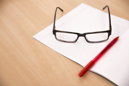 Business composition with laptop glasses and pen over clear pagesの写真素材