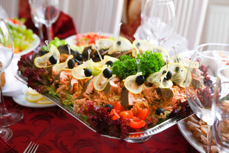 Gefilte fish on a banquet table. Cut into pieces and decorated with vegetables
