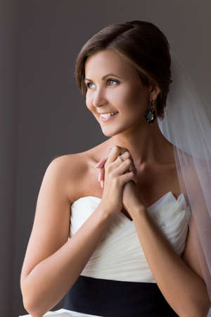 Portrait of a happy bride over gray background.の写真素材