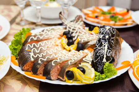 Large stuffed pike with vegetables on the tableの写真素材