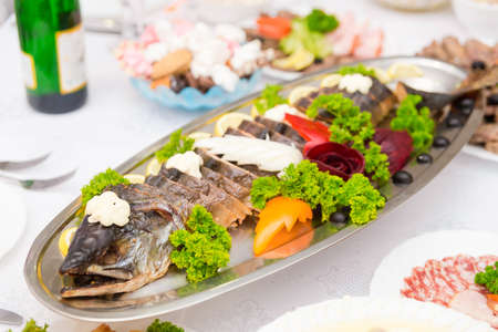 Large stuffed pike with vegetables on the tableの写真素材